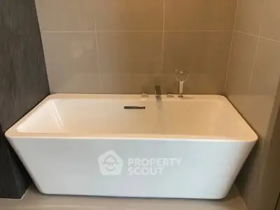 Modern bathroom with sleek freestanding bathtub and elegant tile design.