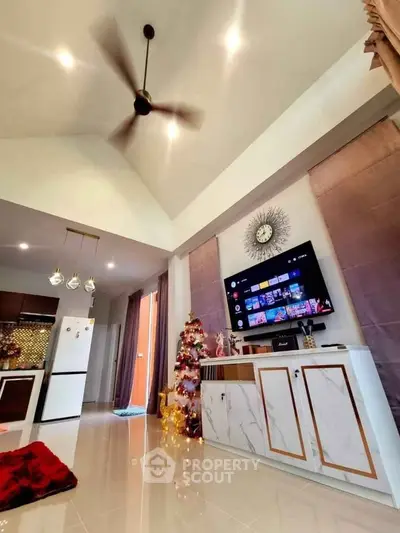 Modern living room with high ceiling, stylish decor, and open kitchen layout