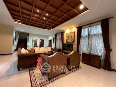 Luxurious living room with elegant wicker furniture and wooden ceiling accents