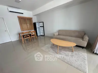 Spacious living room with modern furniture and sleek flooring in a contemporary apartment.