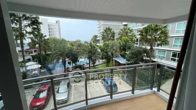 Spacious balcony with pool and garden view in modern apartment complex.