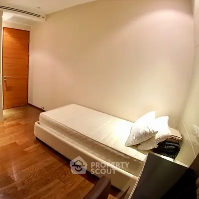 Cozy minimalist bedroom with wooden flooring and simple decor