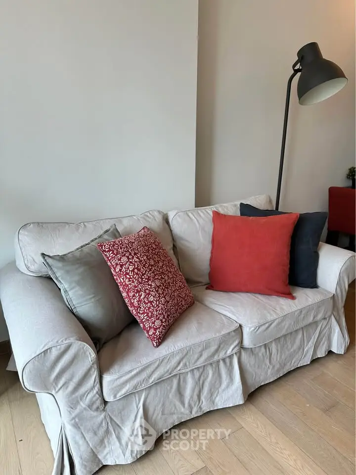 Cozy living room with stylish sofa and floor lamp, perfect for relaxation.