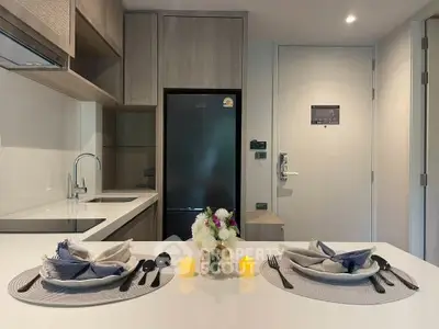 Modern kitchen with sleek design, featuring a fridge and elegant dining setup.