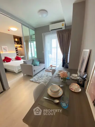 Modern apartment interior with cozy living area and stylish dining setup, featuring a glimpse into a chic bedroom.