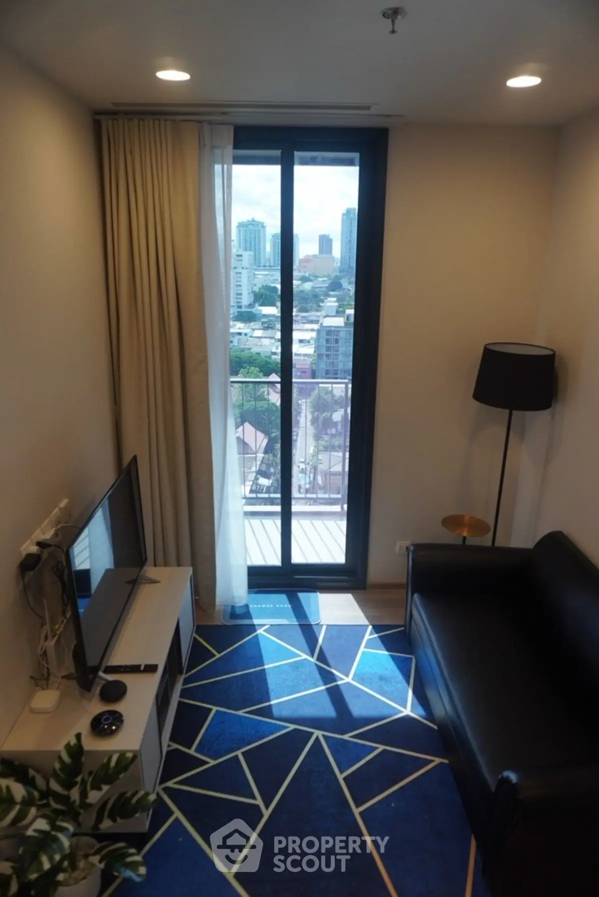 Modern living room with city view, stylish decor, and cozy seating area.