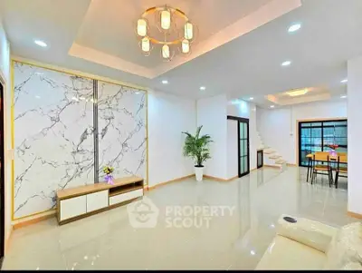 Spacious modern living room with elegant marble accents and stylish lighting.