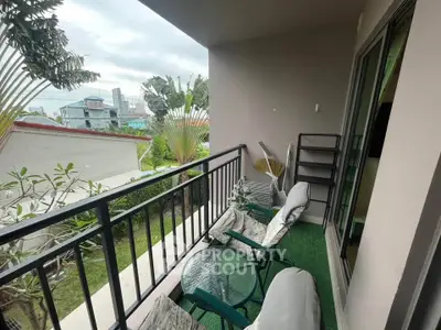 Charming balcony with cozy seating and lush garden view, perfect for relaxation.