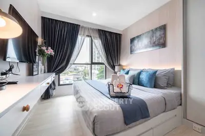 Modern bedroom with stylish decor and large window offering city view