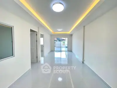 Spacious modern living room with sleek lighting and glossy tiled floor