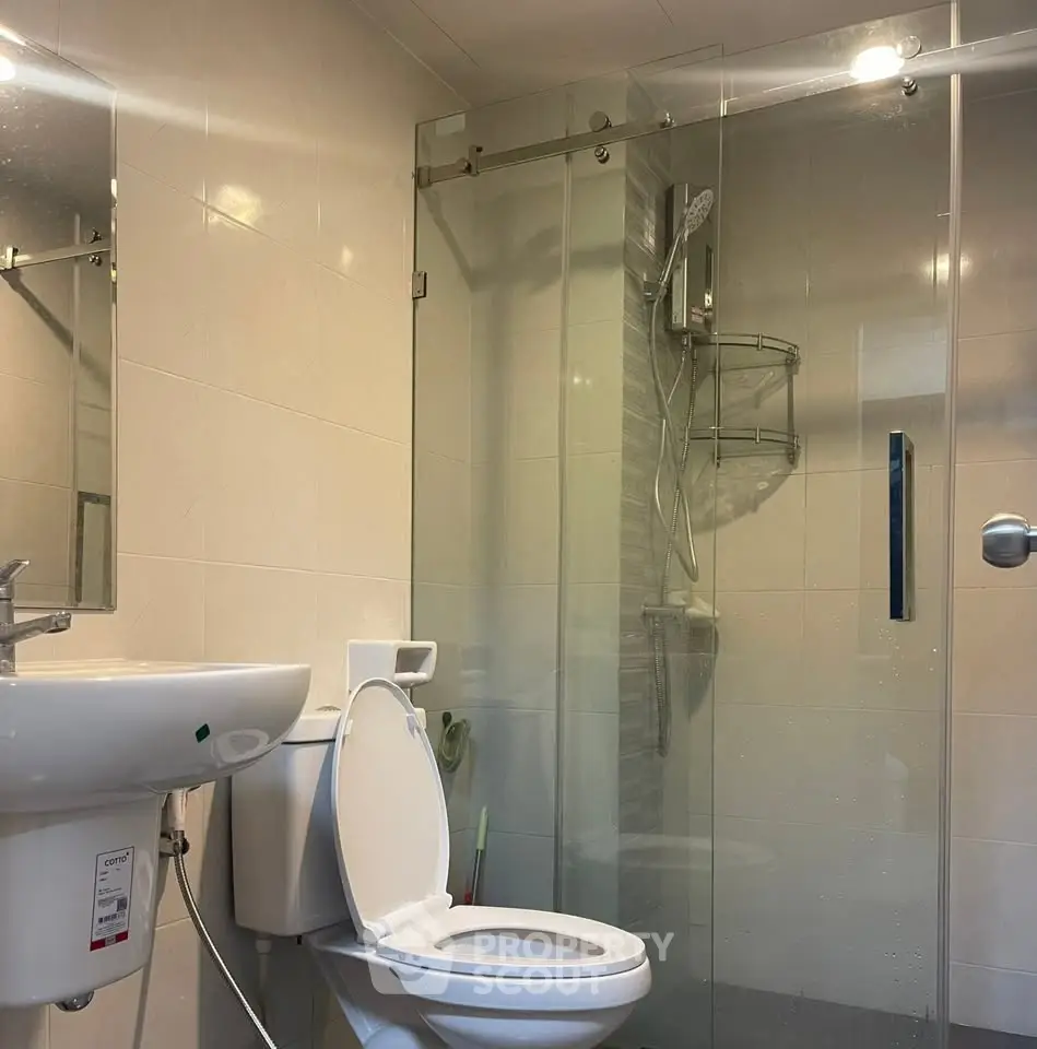 Modern bathroom with glass shower and sleek fixtures in a contemporary home.