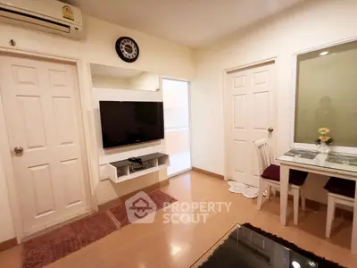 Cozy living room with modern decor and wall-mounted TV in a stylish apartment.