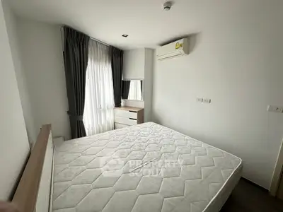 Spacious bedroom with large window and modern furnishings