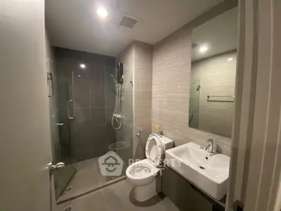 Modern bathroom with glass shower and sleek fixtures in a contemporary apartment.
