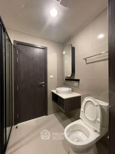Modern bathroom with sleek fixtures and neutral tones, featuring a glass shower and stylish vanity.