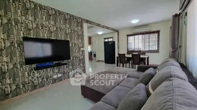 Spacious living room with modern decor and open layout, featuring a cozy sectional sofa and wall-mounted TV.