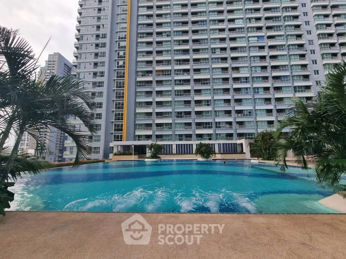 Luxurious high-rise building with stunning pool and lush greenery, perfect for modern urban living.