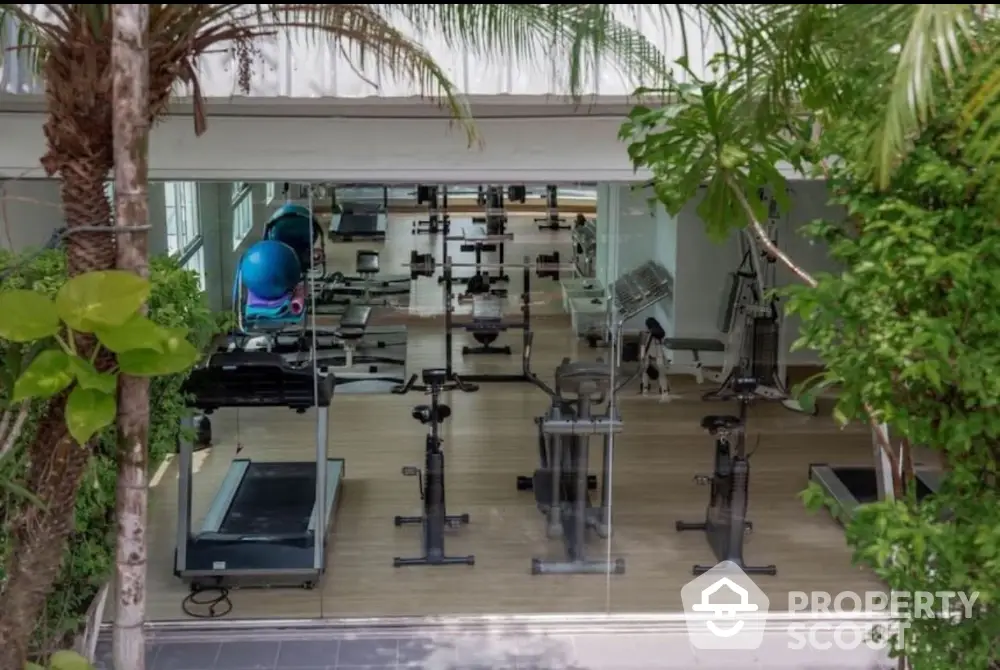 Modern gym with state-of-the-art equipment and lush greenery view.