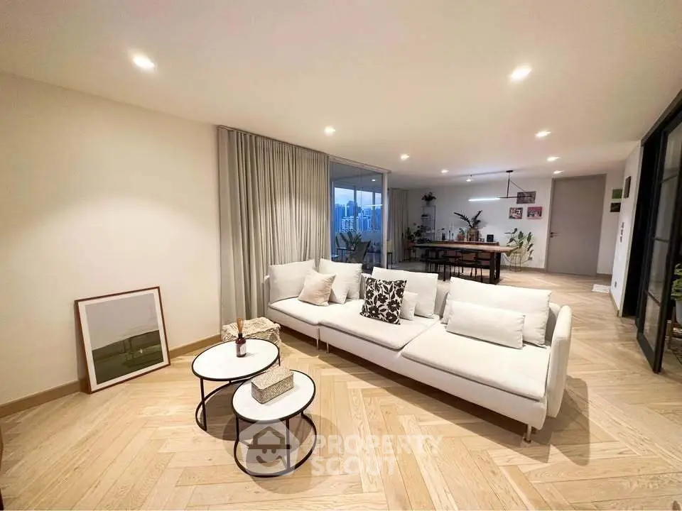 Spacious modern living room with elegant decor and open layout, featuring stylish furniture and ambient lighting.