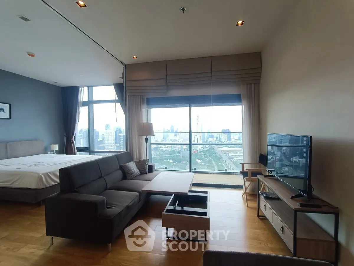 Spacious modern living room with city view, featuring stylish furniture and large windows.