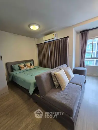 Modern bedroom with stylish decor and natural light, featuring a cozy bed and elegant curtains.