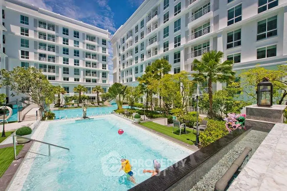 Luxurious residential complex with a stunning outdoor pool and lush garden area.