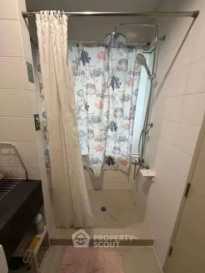 Cozy bathroom with shower curtain and modern fixtures, perfect for a compact urban apartment.