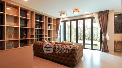 Luxurious living room with plush sofa and garden view through large sliding doors.