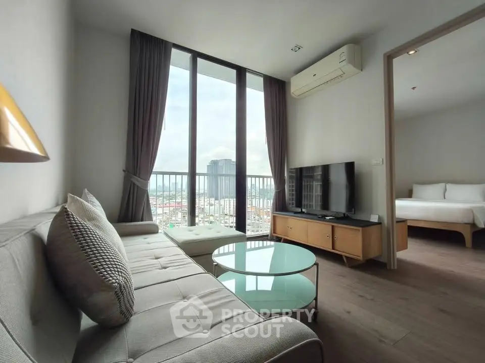 Modern living room with city view, stylish furniture, and natural light.