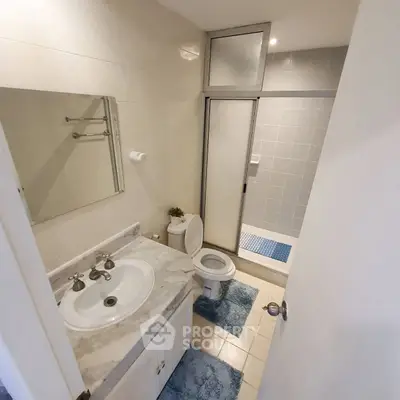 Spacious bathroom with modern fixtures and shower in a real estate property.