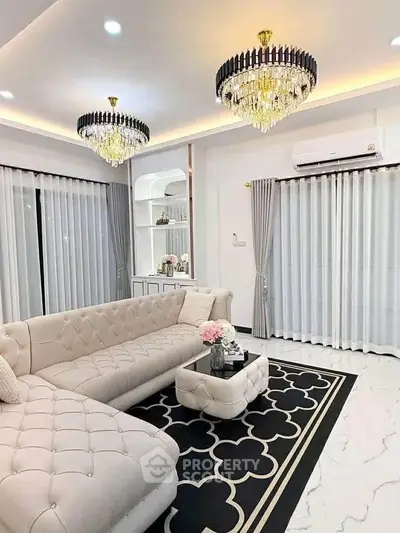 Luxurious living room with elegant chandeliers and plush seating in a modern home.