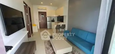 Modern living room with blue sofa and open kitchen layout in stylish apartment.