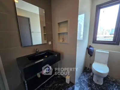 Modern bathroom with sleek black sink and city view window
