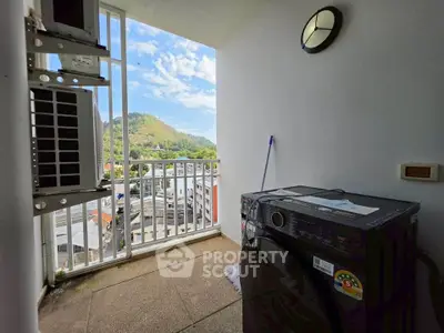 Charming balcony with scenic view and modern washing machine, perfect for urban living.