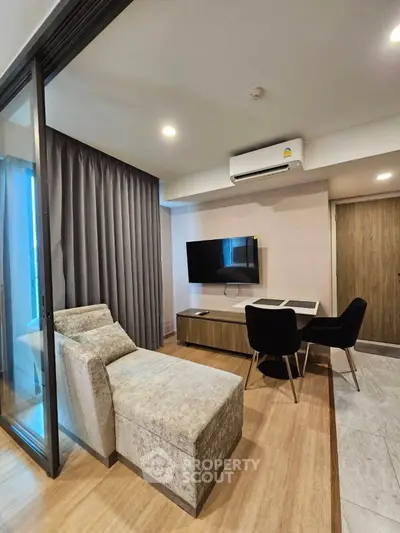 Modern living room with stylish furniture and wall-mounted TV in a cozy apartment setting.