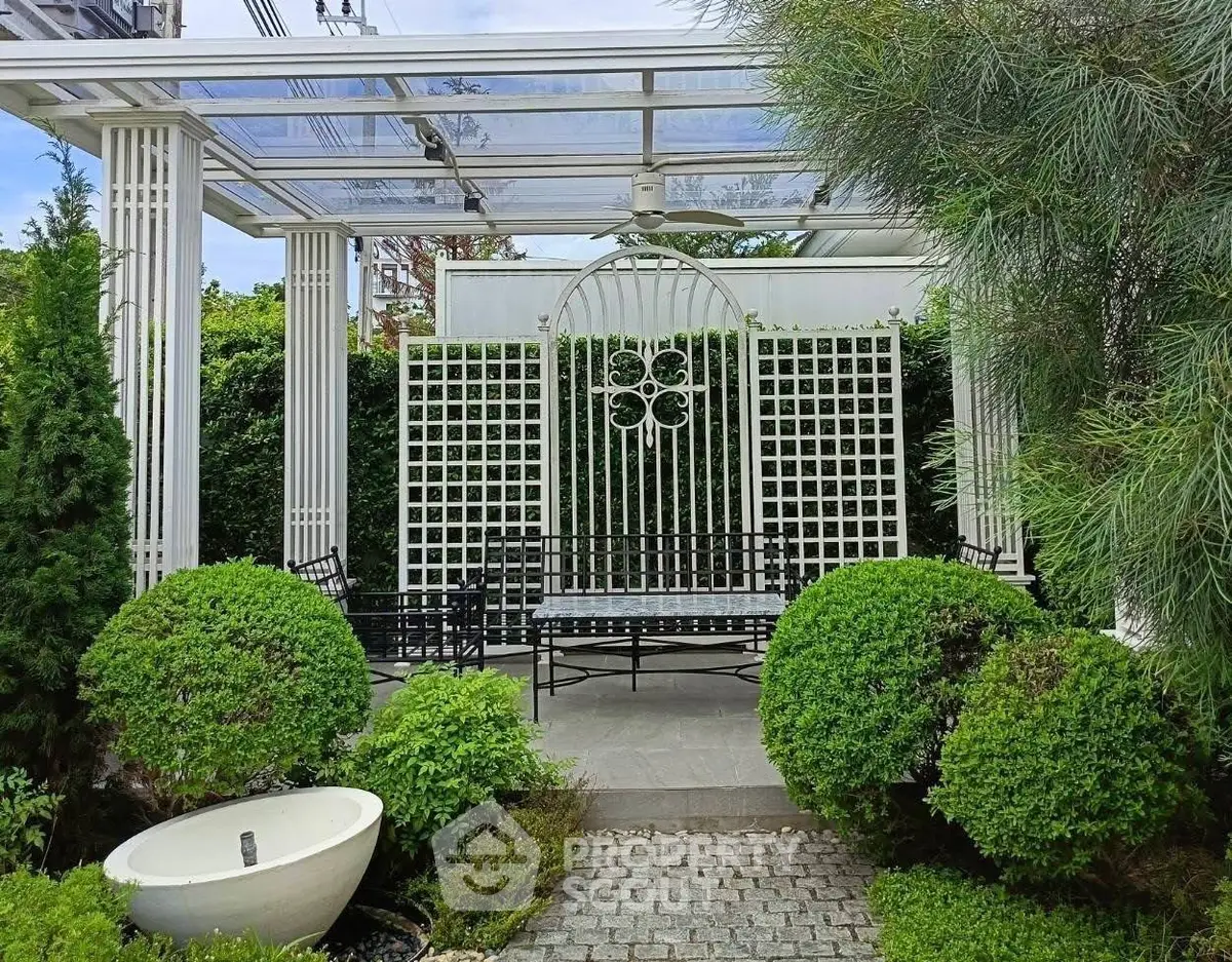 Charming garden with elegant pergola and lush greenery, perfect for outdoor relaxation.