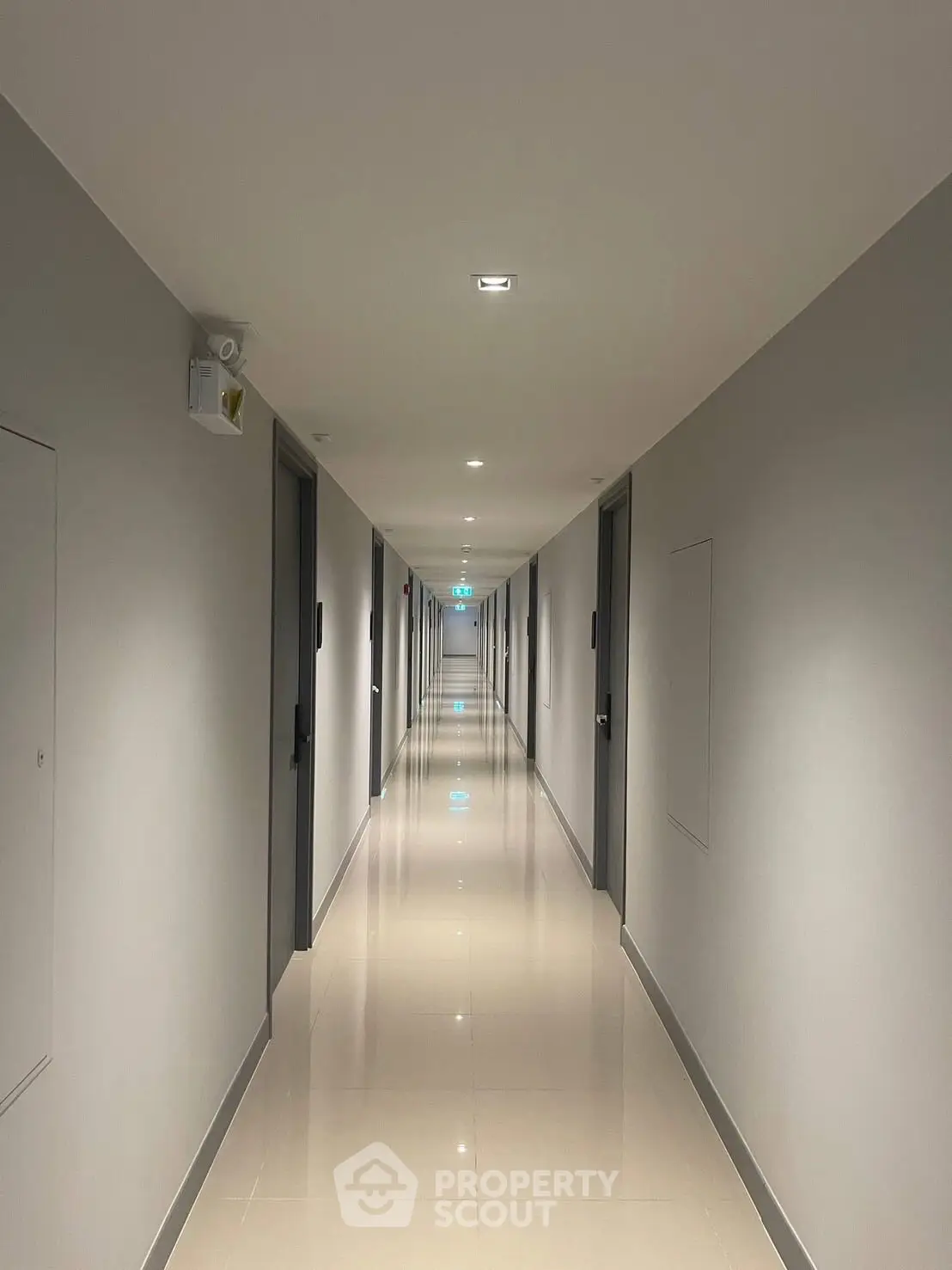 Modern apartment building hallway with sleek design and polished floors.