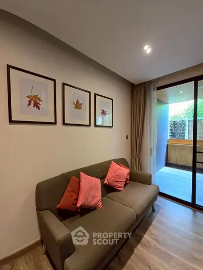 Cozy living room with modern decor and sliding glass doors leading to a spacious balcony.