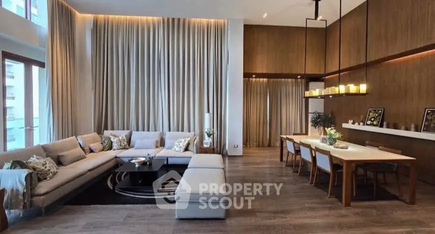 Luxurious open-plan living and dining area with modern decor and high ceilings.