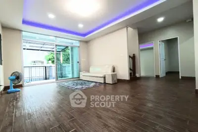 Spacious living room with modern lighting and balcony access