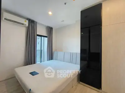 Modern bedroom with sleek design, featuring a large bed, built-in wardrobe, and air conditioning.
