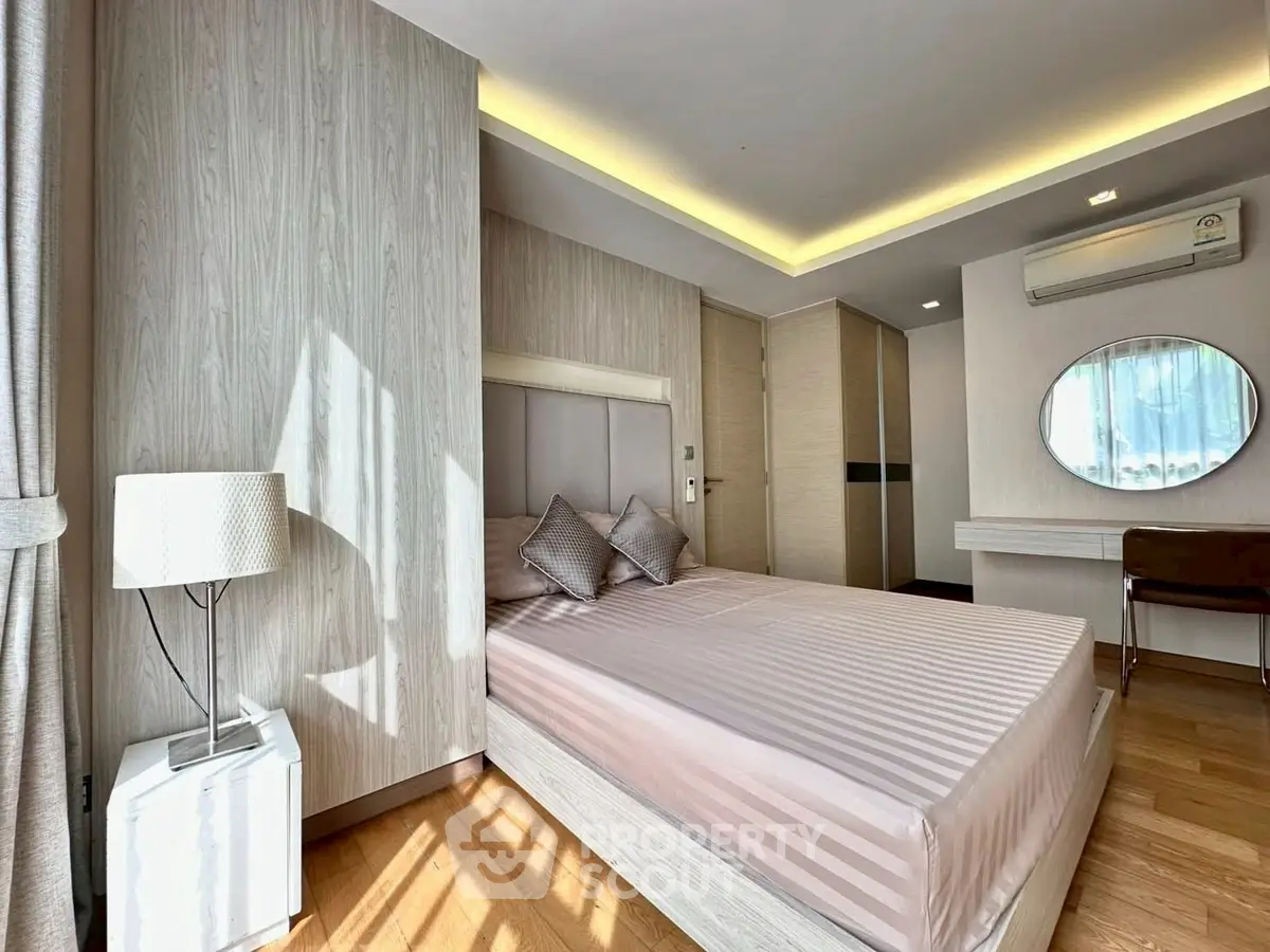 Modern bedroom with stylish decor and natural light, featuring a cozy bed and elegant furnishings.