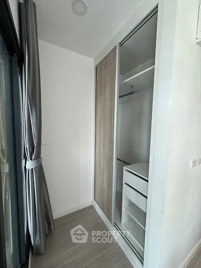 Modern apartment with sleek built-in wardrobe and large window for natural light.