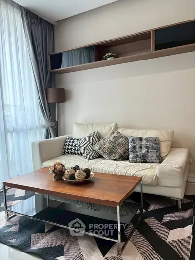 Stylish living room with modern decor, featuring a cozy white sofa, chic cushions, and a sleek wooden coffee table.