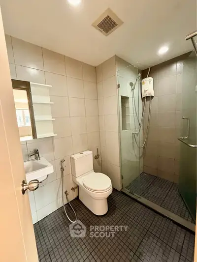 Modern bathroom with glass shower and sleek fixtures in a contemporary apartment.