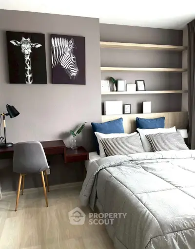 Modern bedroom with stylish decor and cozy bedding, featuring a study desk and wall art.