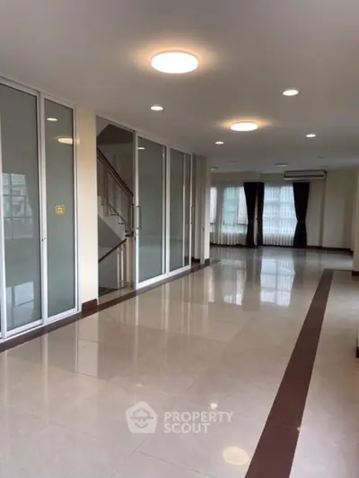 Spacious modern living room with large windows and elegant lighting