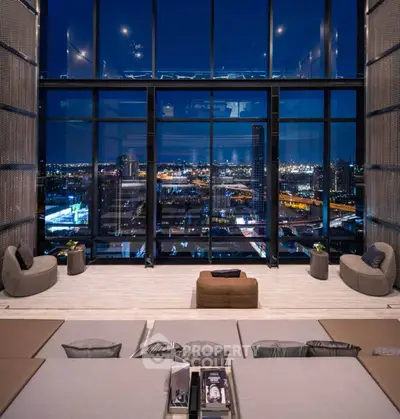 Luxurious high-rise living room with stunning city skyline view at night.