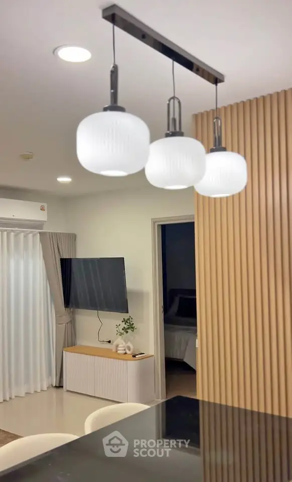 Modern living room with stylish pendant lights and sleek TV setup