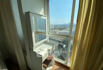 Bright corner unit with stunning city view and natural light, featuring a cozy vanity area by the window.
